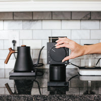 Fellow Ode Black Grinder in situ with hand on grind knob