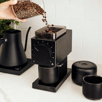 Fellow Ode Black Grinder with beans being poured in